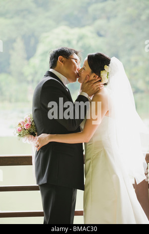 Braut und Bräutigam küssen Stockfoto