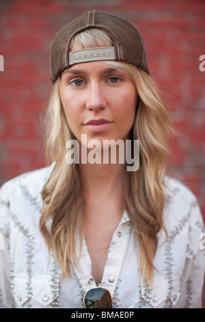 Close-up Portrait der Frau stand vor Backsteinmauer Stockfoto