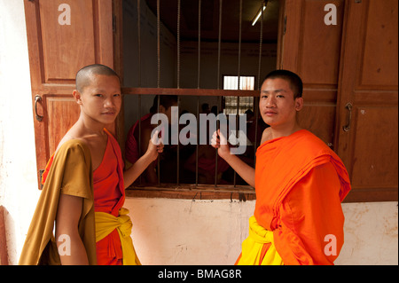 Zwei buddhistische Mönche am Fenster ihres Zimmers Schule in Luang Prabang Laos Stockfoto