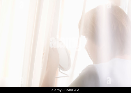 Reife Frau schaut Reflexion in der hand Spiegel Stockfoto
