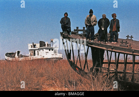 Moynaq Usbekistan Jungen spielen auf die rostigen Wracks von Fischkuttern, blieben als der Aralsee entschwanden gestrandet. Stockfoto