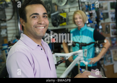 Fahrrad-Shop-Assistent mit weiblichen Radfahrer Stockfoto