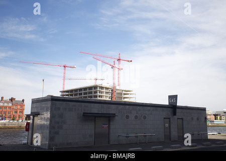 Elektrische Umspannanlage am Ufer von liffey mit Kränen in Büroblöcken an den nördlichen Kais von IFSC, Dublin, Irland Stockfoto