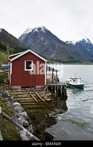 Gebäude in Mundal Dorf am Ufer des Fjaerlandsfjorden Fjaerland mit Schnee bedeckt Bergen reflektiert in Norwegen Stockfoto