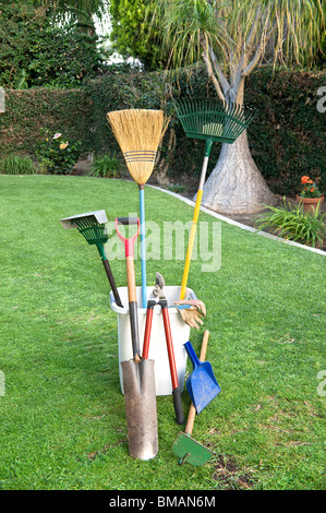 Arbeits- und Gartenarbeit Tools auf grünen Rasen und einen gepflegten Garten Hof. Stockfoto