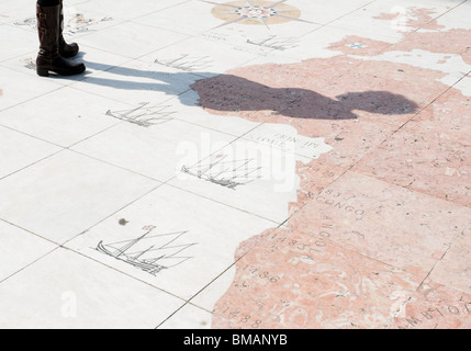 Besucher auf dem Bürgersteig Kompass vor dem Denkmal der Entdeckungen in Lissabon werfen ihre Schatten über der Karte Gesicht. Stockfoto