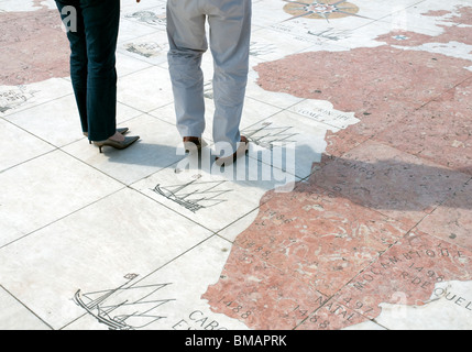 Besucher auf dem Bürgersteig Kompass vor dem Denkmal der Entdeckungen in Lissabon werfen ihre Schatten über der Karte Gesicht. Stockfoto