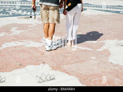 Besucher auf dem Bürgersteig Kompass vor dem Denkmal der Entdeckungen in Lissabon werfen ihre Schatten über der Karte Gesicht. Stockfoto