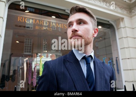 Eine Schneider-Assistent steht außen Richard James-Shop in Savile Row, London. Stockfoto