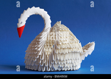 Origami Swan auf blauem Hintergrund isoliert - die Kunst des Papierfaltens Stockfoto