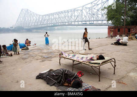 Aktivitäten auf Babu Ghat; Howrah Brücke über Hooghly Fluß im Hintergrund; Calcutta jetzt Kolkata; Westbengalen; Indien Stockfoto