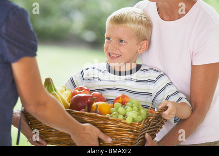 Ein Junge geben einen Korb mit Früchten Stockfoto