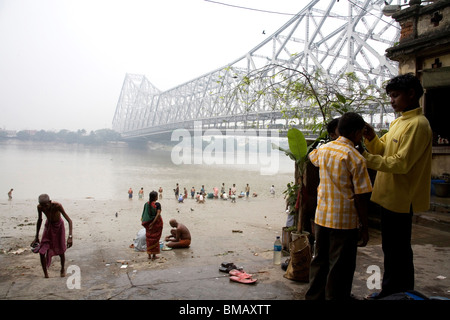 Aktivitäten auf Babu Ghat; Howrah Brücke über Hooghly Fluß im Hintergrund; Calcutta jetzt Kolkata; Westbengalen; Indien Stockfoto