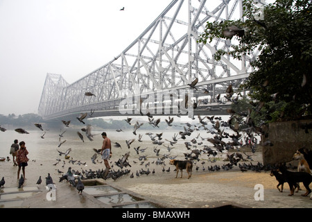 Aktivitäten auf Babu Ghat; Howrah Brücke über Hooghly Fluß im Hintergrund; Calcutta jetzt Kolkata; Westbengalen; Indien Stockfoto
