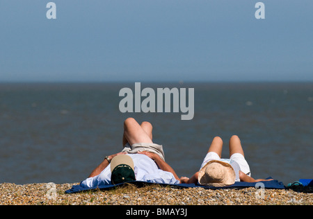 Zwei Personen zum Sonnenbaden am Strand von Sizewell in Suffolk.  Foto von Gordon Scammell Stockfoto