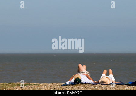 Zwei Personen zum Sonnenbaden am Strand von Sizewell in Suffolk.  Foto von Gordon Scammell Stockfoto