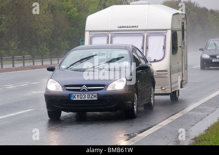 Zweispurige Straße UK Schlechtwetter regen Nebel Spray dunkle Britische Sommerzeit Urlaub Auto abschleppen Wohnwagen in miserable Wetter Stockfoto