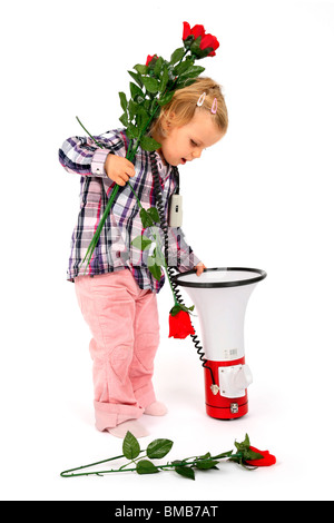 kleines Mädchen, rote Rosen in einem Megaphon Stockfoto