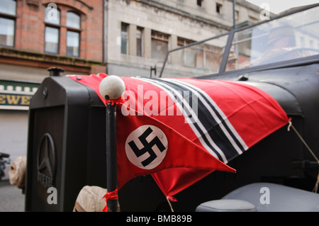 Nazi-Flaggen auf der Motorhaube eines Bundeswehr-LKW bei den Dreharbeiten eines Films in Berlin der 1930er Jahre gesetzt. Stockfoto