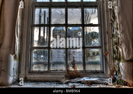 Blick auf den Kraftstoff Silos & Power House Schornsteine durch Krankenhaus Fenster in verlassene psychiatrische Anstalt Stockfoto