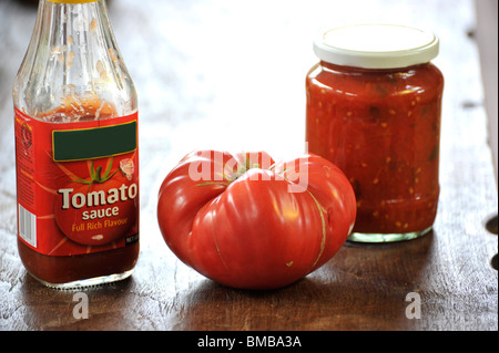 Eine generische Supermarkt Tomatensauce neben einer hausgemachten Version mit Beefsteak Tomaten. Stockfoto