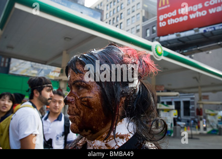 Demonstranten verschütten flüssiges Öl vertritt über sich selbst vor einer BP-Tankstelle in Soho in New York Stockfoto