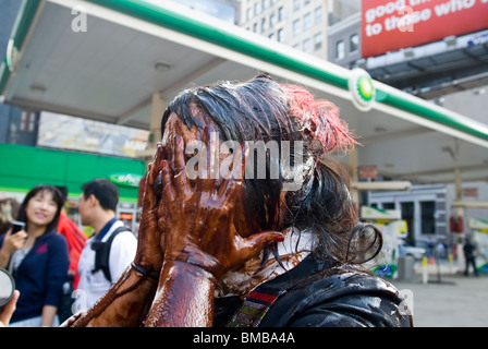 Demonstranten verschütten flüssiges Öl vertritt über sich selbst vor einer BP-Tankstelle in Soho in New York Stockfoto