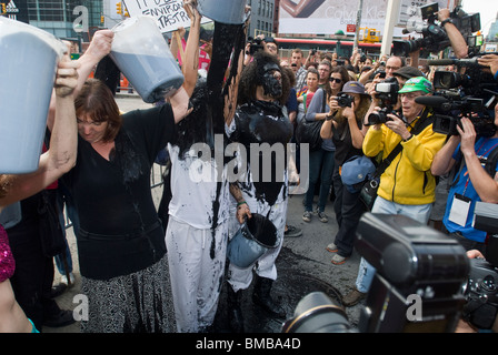 Demonstranten verschütten flüssiges Öl vertritt über sich selbst vor einer BP-Tankstelle in Soho in New York Stockfoto