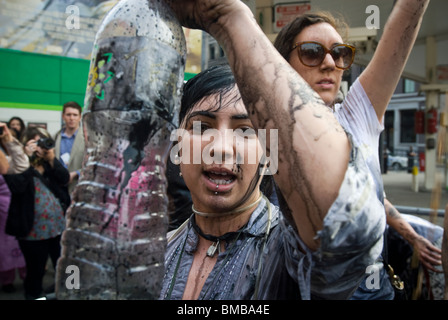 Demonstranten verschütten flüssiges Öl vertritt über sich selbst vor einer BP-Tankstelle in Soho in New York Stockfoto