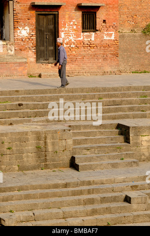 nepalesische Greis zu Fuß entlang der Aussichtspunkt mit Blick auf die Feuerbestattung Ghats am Pashupatinath Hindu Tempel, Kathmandu, nepal Stockfoto