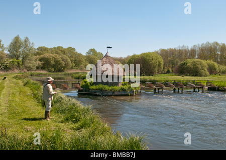 Fliegenfischen Sie auf dem Fluss-Test in Longstock, Hampshire, England. Reusen und einer Gillies schilfgedeckten Hütte zu sehen. Stockfoto