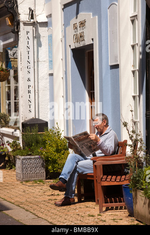 Großbritannien, England, Devon, Dartmouth, Mann saß in der Sonne lesen Zeitung Stockfoto