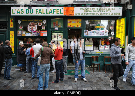 Kunden, die sich vor dem L'as du Fallafel-Geschäft im Marais-Viertel von Paris, Frankreich, in der Warteschlange befinden. Stockfoto