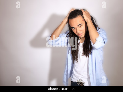 Junger Mann mit Angst sperrt fegt seine Haare Rückseite mit Blick auf Kamera Stockfoto