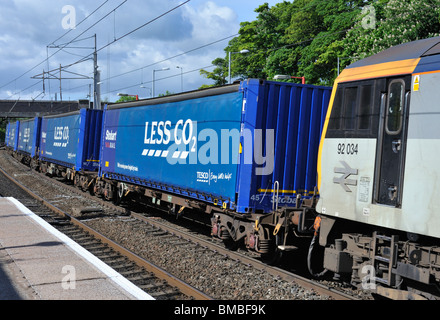 EWS-Klasse 92 Lokomotiven 92034 "Kipling" schleppen Tesco Frachtcontainern. Oxenholme Bahnhof West Coast Main Line, Cumbria. Stockfoto