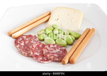 Dicke Bohnen mit Pecorino Käse Grissini und Salami-Scheiben auf einem weißen Teller mit Beschneidungspfad isoliert Stockfoto