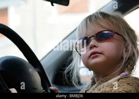 Stock Foto von einem vier Jahre alten Mädchen vorgibt, das Auto zu fahren. Stockfoto