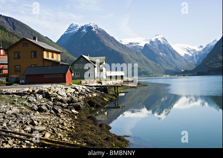 Gebäude in Mundal Dorf am Ufer des Fjaerlandsfjorden Fjaerland mit Schnee bedeckt Bergen reflektiert in Norwegen Stockfoto