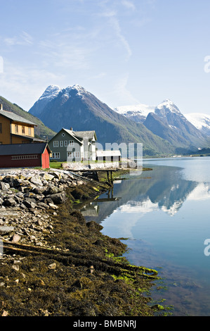 Gebäude in Mundal Dorf am Ufer des Fjaerlandsfjorden Fjaerland mit Schnee bedeckt Bergen reflektiert in Norwegen Stockfoto