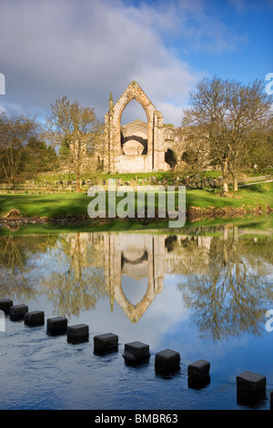 Ansicht von Bolton Priory, ein Augustiner Kloster mit Trittsteine crossing The River Wharfe, in der Nähe von Skipton, Yorkshire Dales, UK Stockfoto