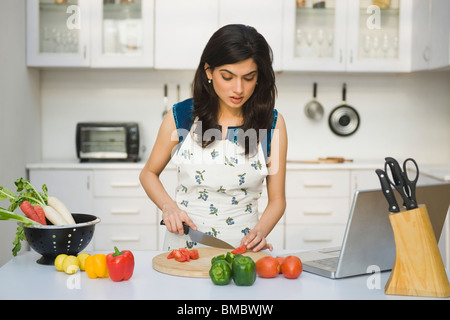 Frau hacken Tomaten in der Küche Stockfoto