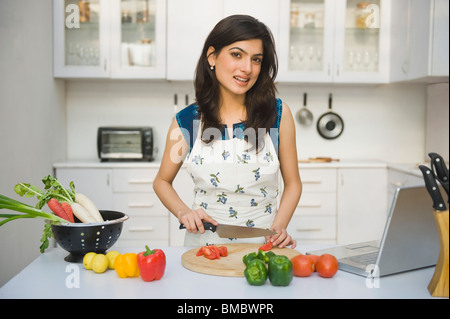 Frau hacken Tomaten in der Küche Stockfoto