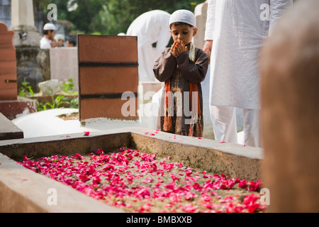 Junge mit seinem Vater an einem Grab auf einem Friedhof, Alt-Delhi, Indien beten Stockfoto
