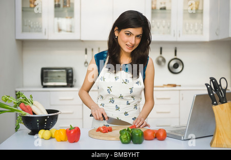 Frau hacken Tomaten in der Küche Stockfoto