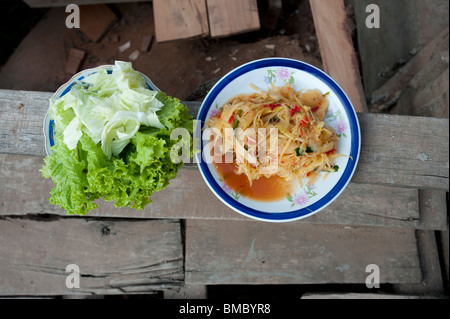 Schüsseln mit Essen auf einer Holzbank in Laos Stockfoto