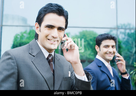 Zwei Geschäftsleute sprechen auf dem Handy Stockfoto