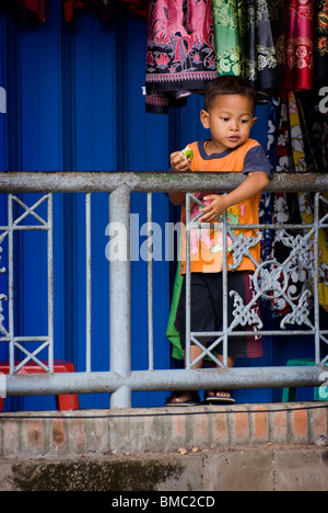 Ein balinesischer junge wacht über Ubud, Bali, öffentlichen Markt wartet auf seine Mutter, die Lebensmittel einkaufen für den Tag zu beenden. Stockfoto