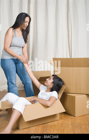 Frau und Tochter spielen mit Kartons Stockfoto