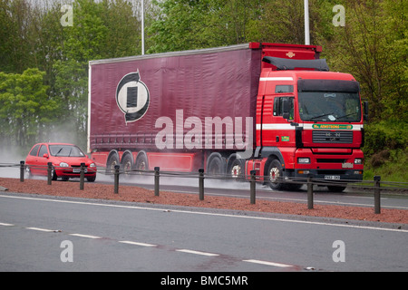 Zweispurige Straße Schlechtwetter regen Nebel Spray Auto überholen eines LKW Feierabendverkehr UK Stockfoto