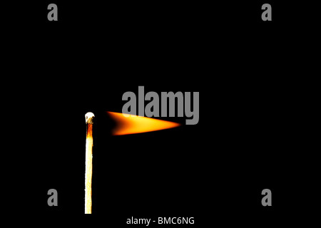 ein brennendes Zündholz als Flagge vor schwarzem Hintergrund Stockfoto